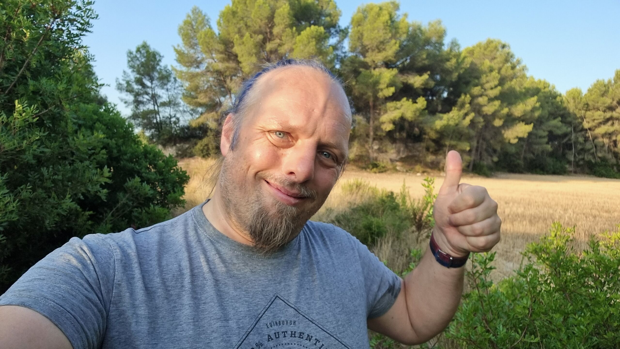 Full image of Dan throws a 'thumbs up' to the camera.