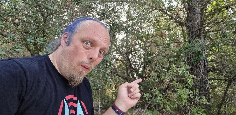 Dan points towards some bushes.