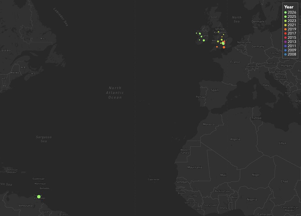 Map showing countries on both sides of the Atlantic, with coloured dots representing my geohashing expeditions mostly littering England and Ireland but with just one way out in Trinidad.