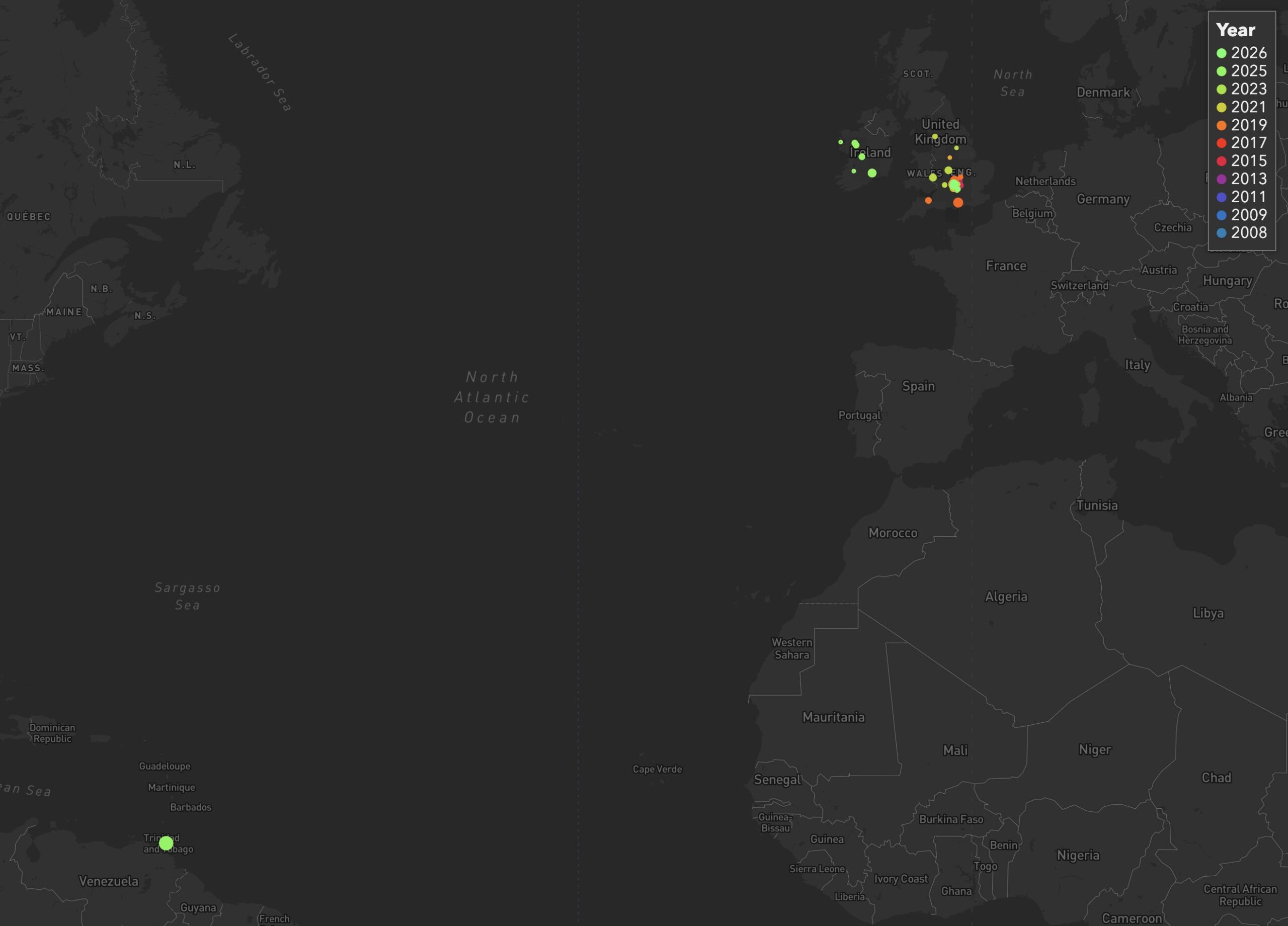 Full image of Map showing countries on both sides of the Atlantic, with coloured dots representing my geohashing expeditions mostly littering England and Ireland but with just one way out in Trinidad.