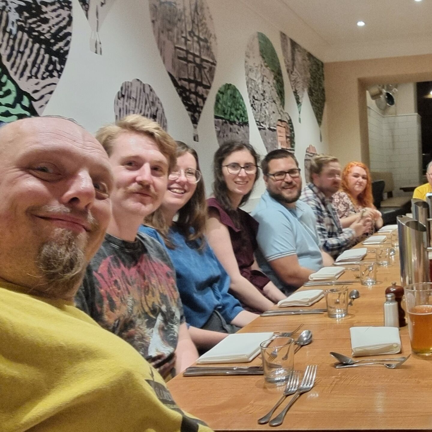 Full image of A row of volunteers sit at a dining table.
