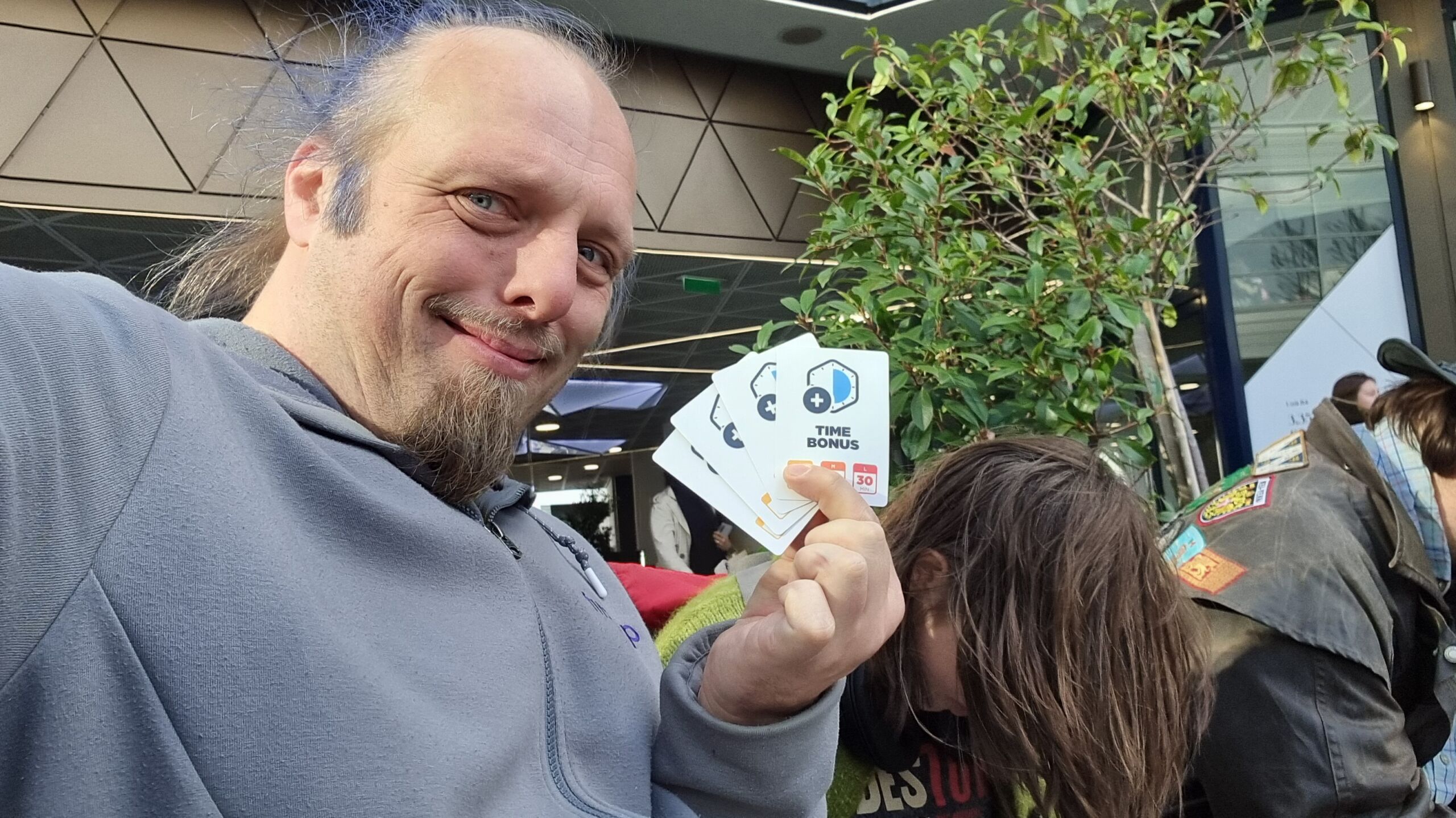 Full image of Dan holding a fan of 'time bonus' cards.