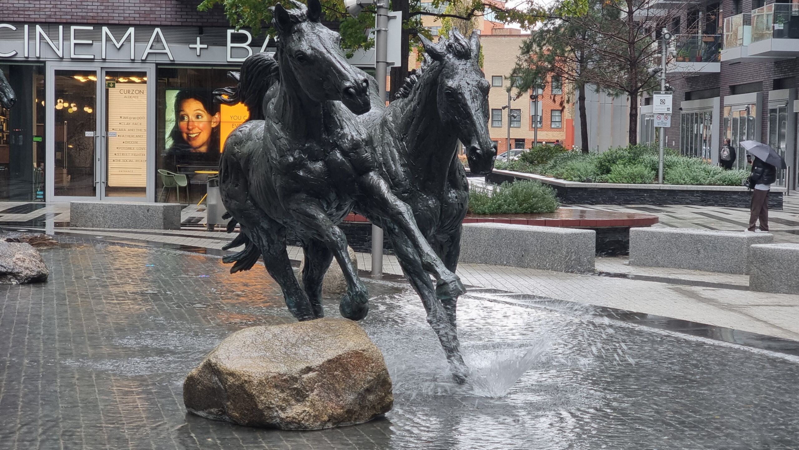 Full image of Statue of two horses with small fountains giving the appearance of them kicking up water as they run.
