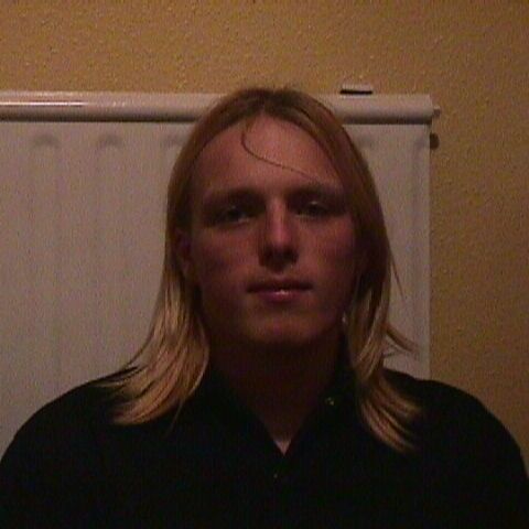 Dan, aged around 16/17, sits in front of a radiator, facing the camera.