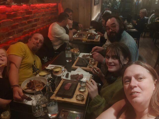 A family take a selfie in a steak restaurant, leaning to fit into the frame.