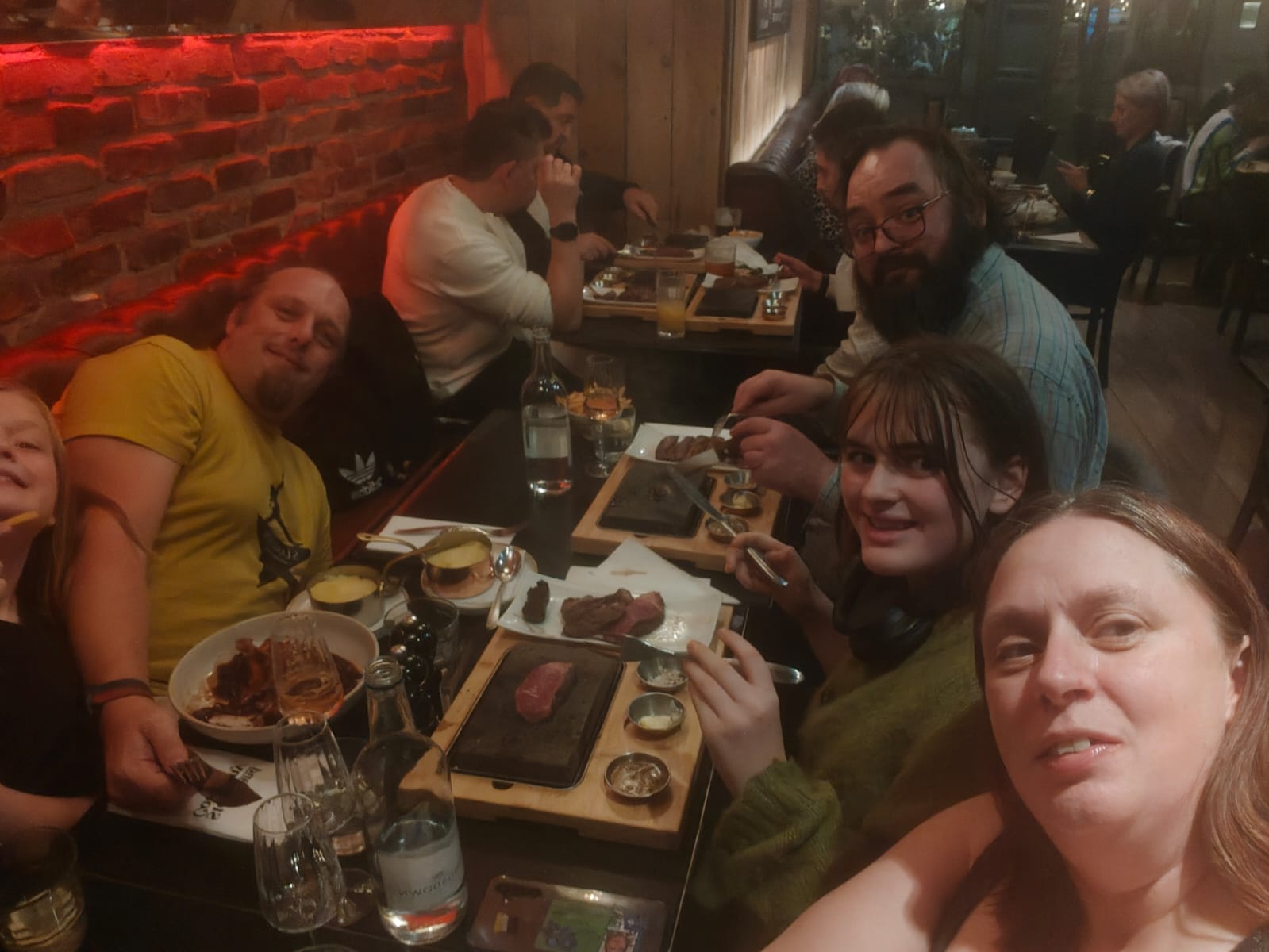 Full image of A family take a selfie in a steak restaurant, leaning to fit into the frame.