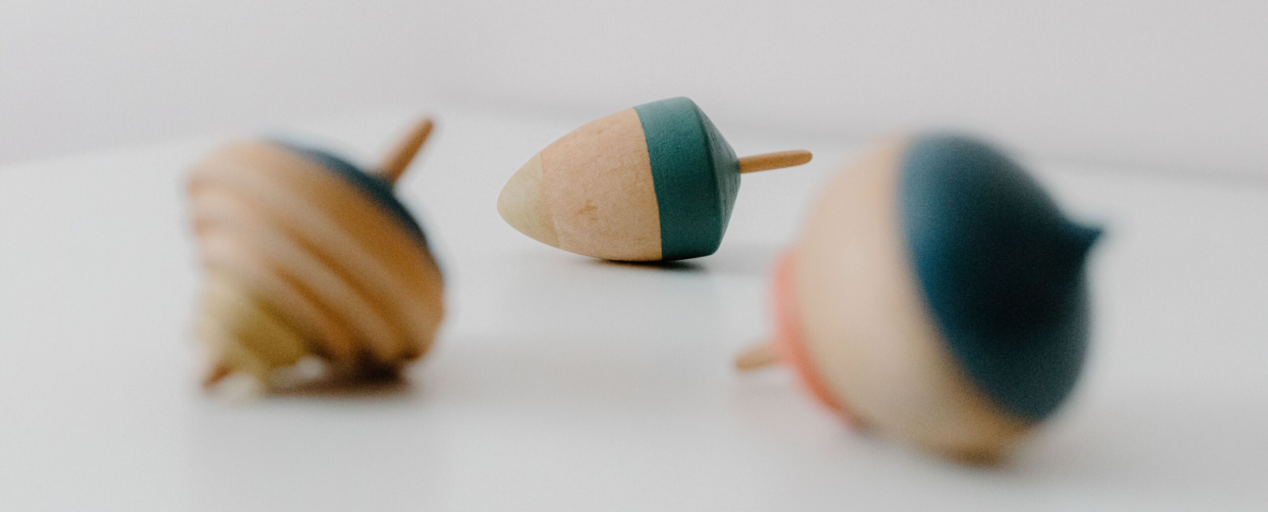 Full image of Three wooden spinning tops lying on their sides.